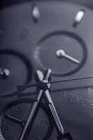 Close-up of the watch face showcasing rose gold hands against a deep navy dial with jet black gradient background.