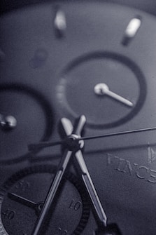 Close-up view of a sophisticated watch face, highlighting the precision of its hands and dials with a sleek, metallic finish.