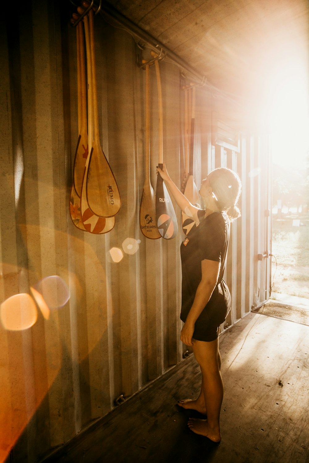 woman in black tank top and black shorts holding brown acoustic guitar