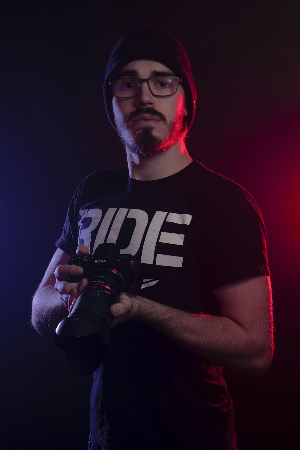 man in black and white crew neck t-shirt holding black dslr camera