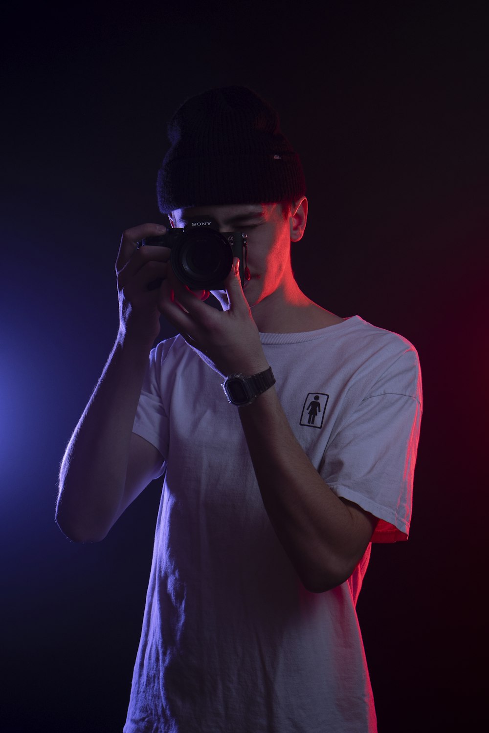 man in white crew neck t-shirt holding black camera