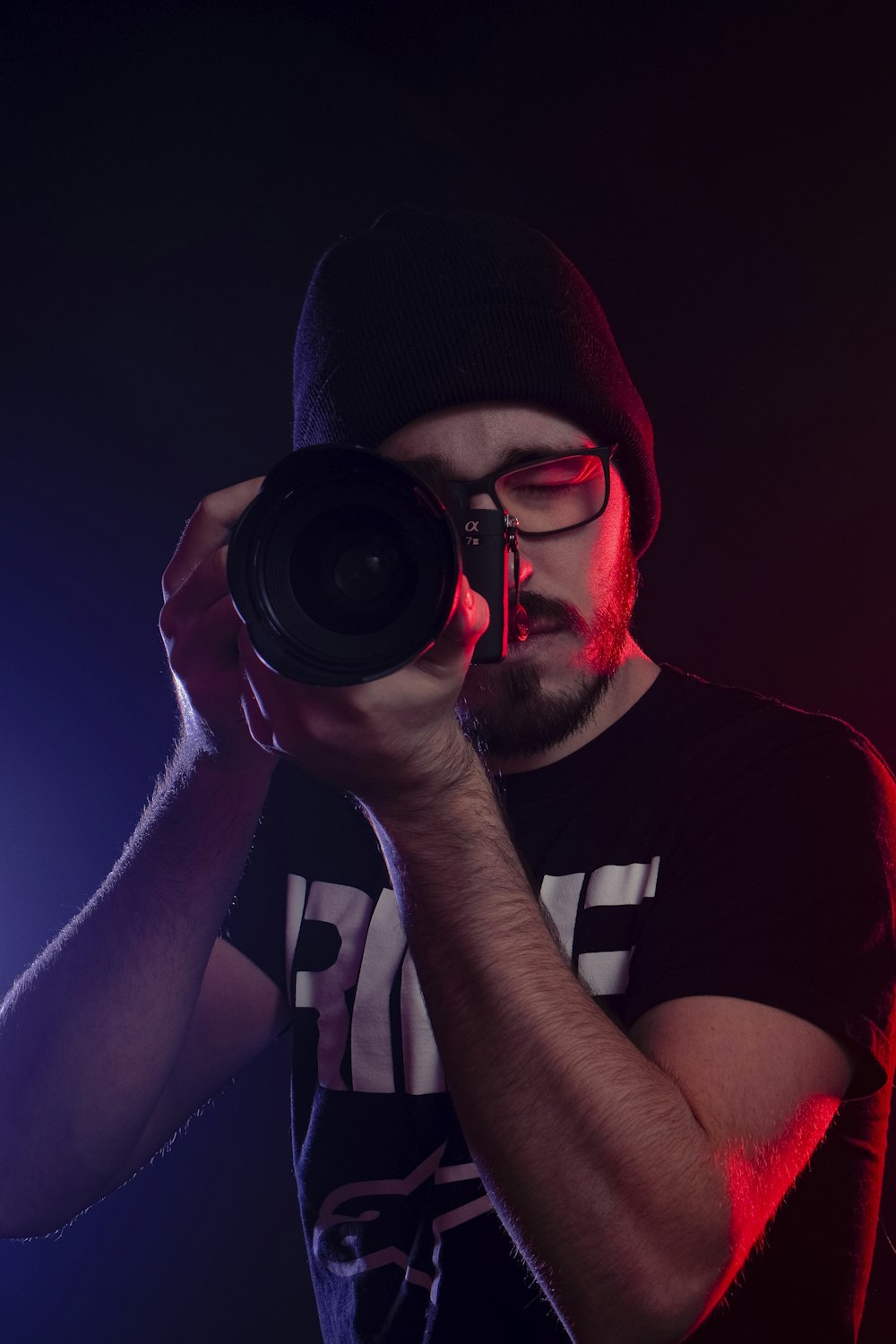 man in black and white crew neck t-shirt holding black dslr camera