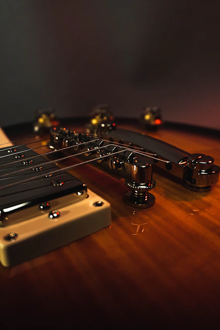 Close-up of a handcrafted Stratocaster guitar with rich wood grain and dramatic lighting highlighting its premium finish.