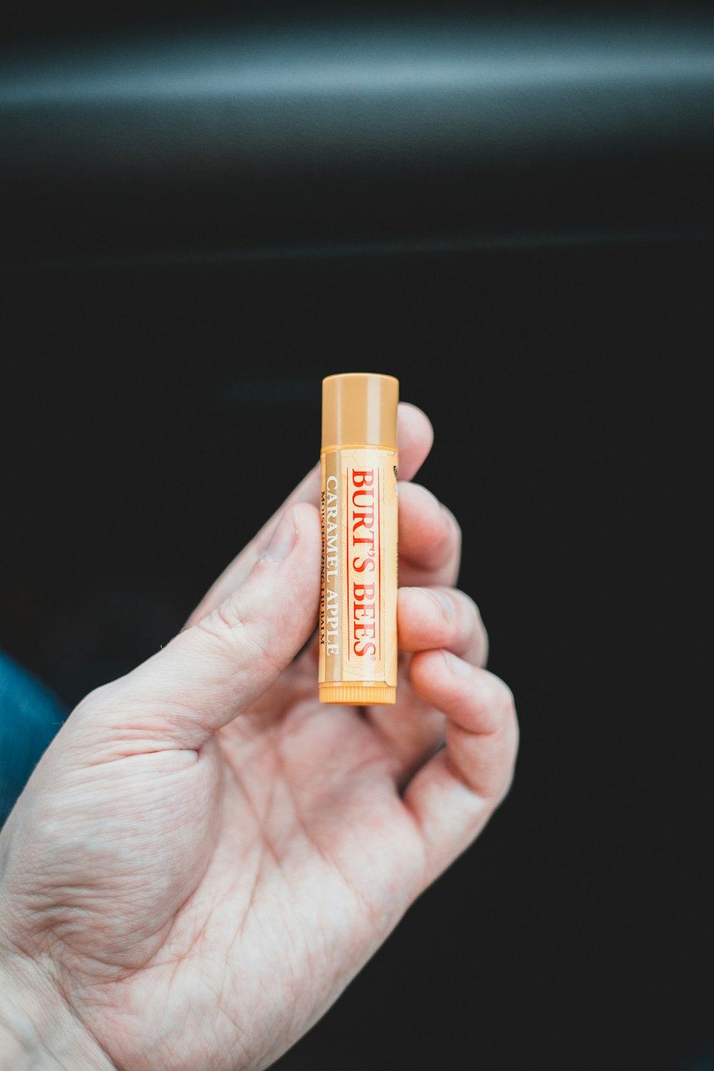 person holding orange and yellow plastic tube