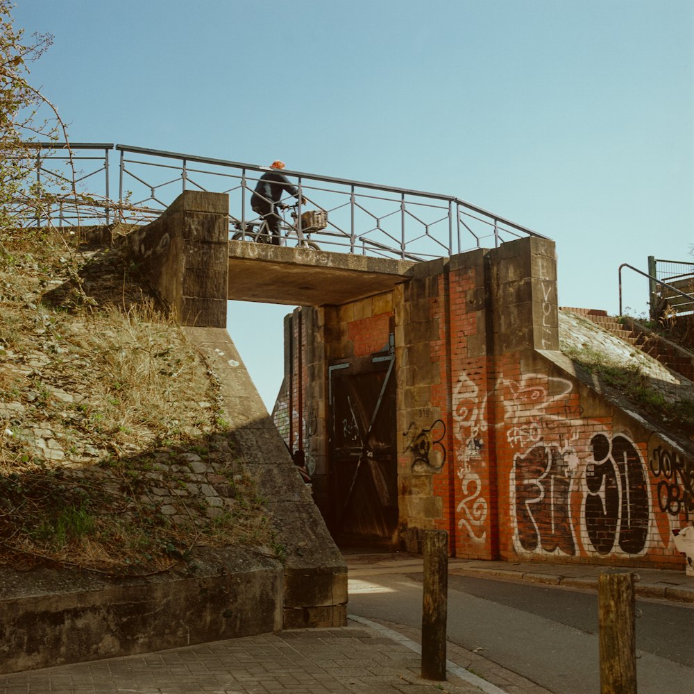 man in black shirt sitting on brown concrete wall during daytime