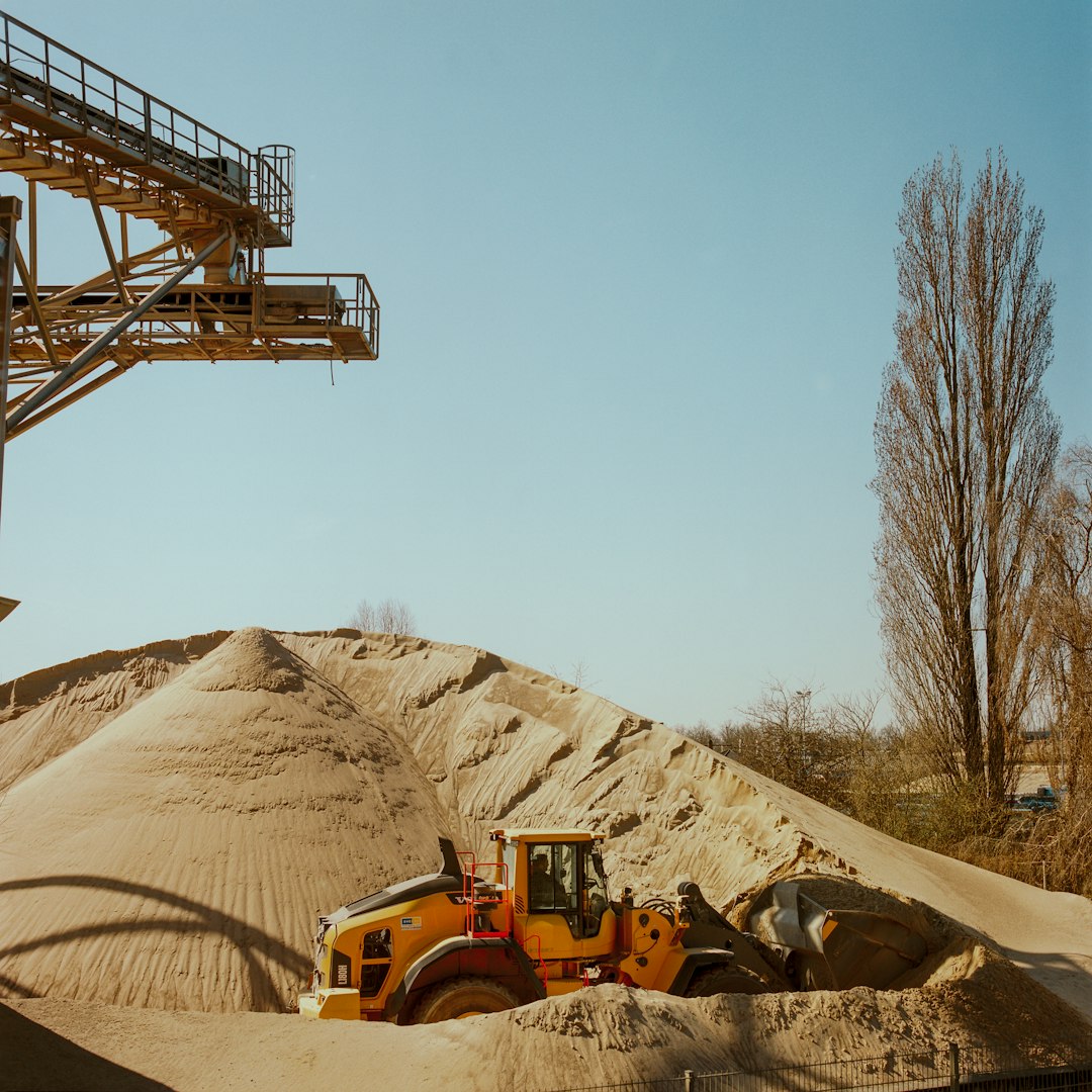 yellow and black heavy equipment on brown sand during daytime