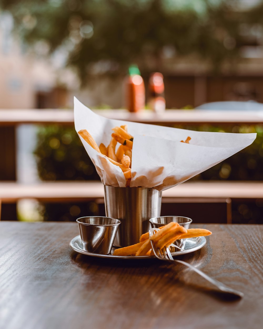 stainless steel cup with ice cream on brown wooden table