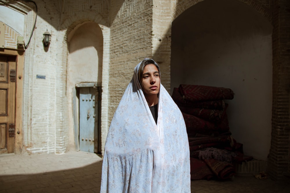 woman in white robe standing on gray concrete stairs