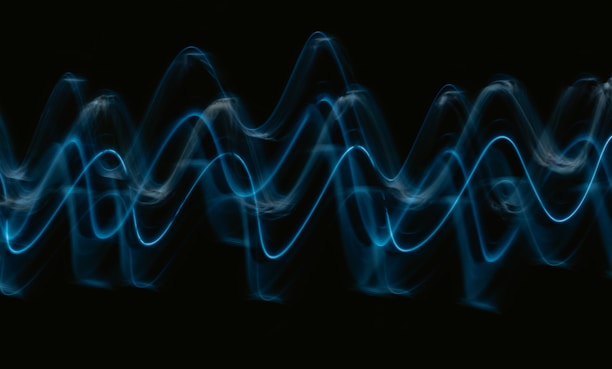 a black background with a blue wave of light