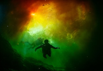 A vibrant underwater scene showcasing divers wearing colorful wetsuits.