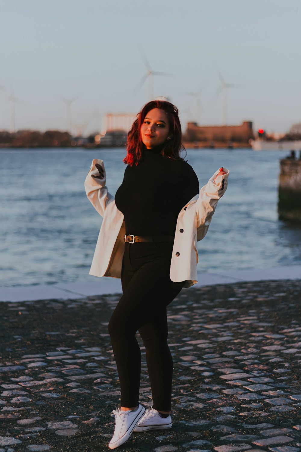 woman in black jacket and black pants standing on wet ground