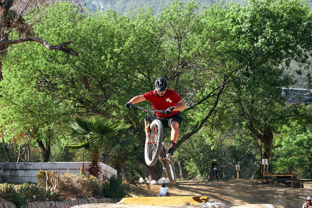 man in red shirt riding on bicycle,