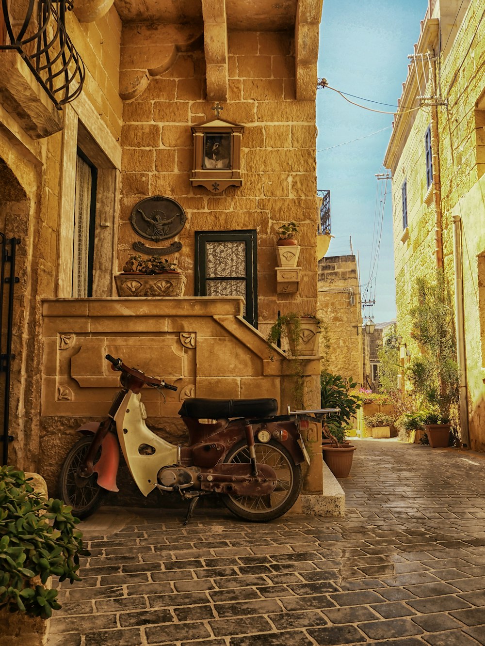 black motorcycle parked beside brown concrete building during daytime