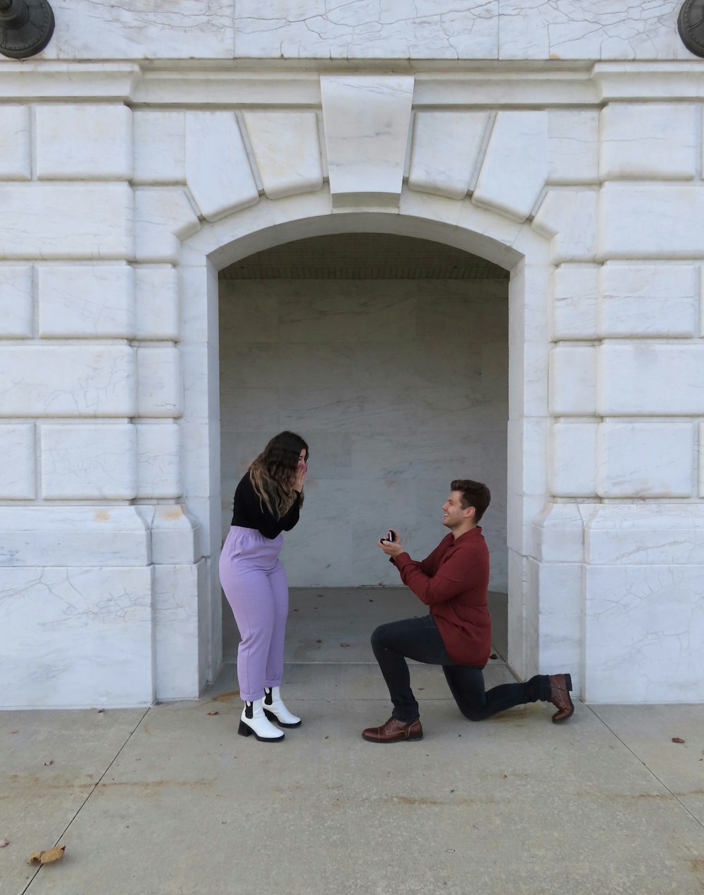 man and woman sitting on concrete bench