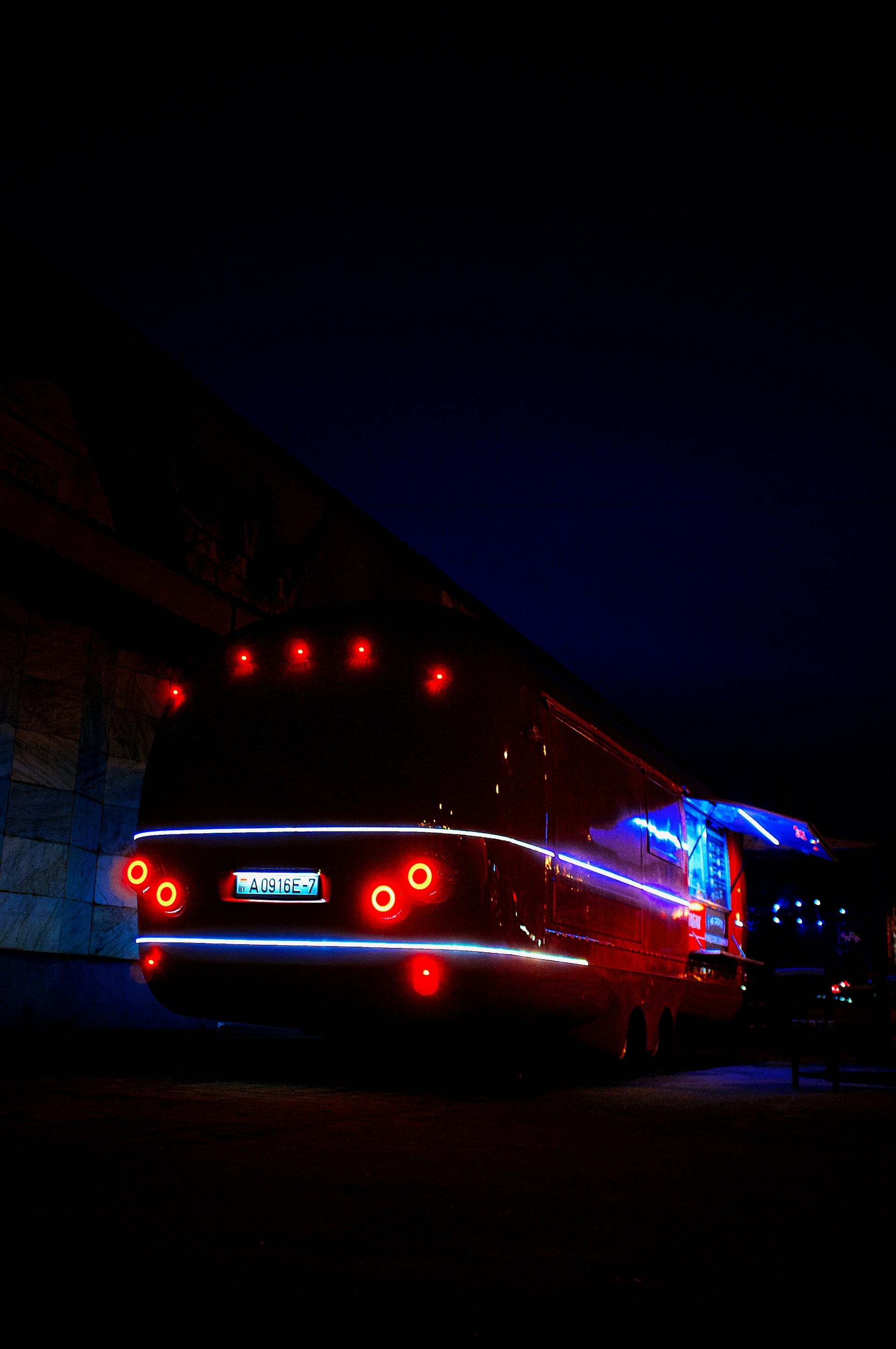 red and white bus on road during nighttime