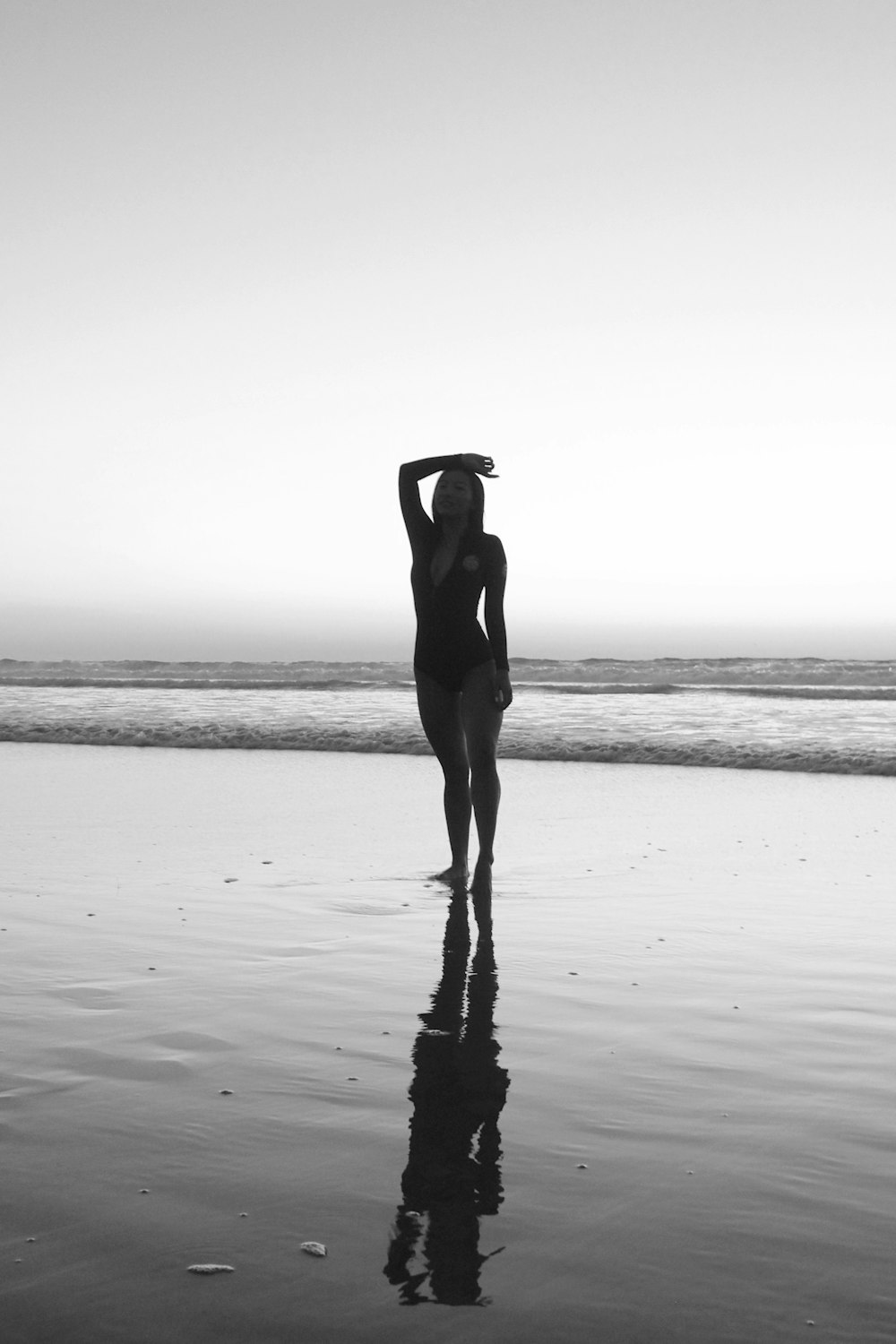 woman in black dress standing on beach during daytime