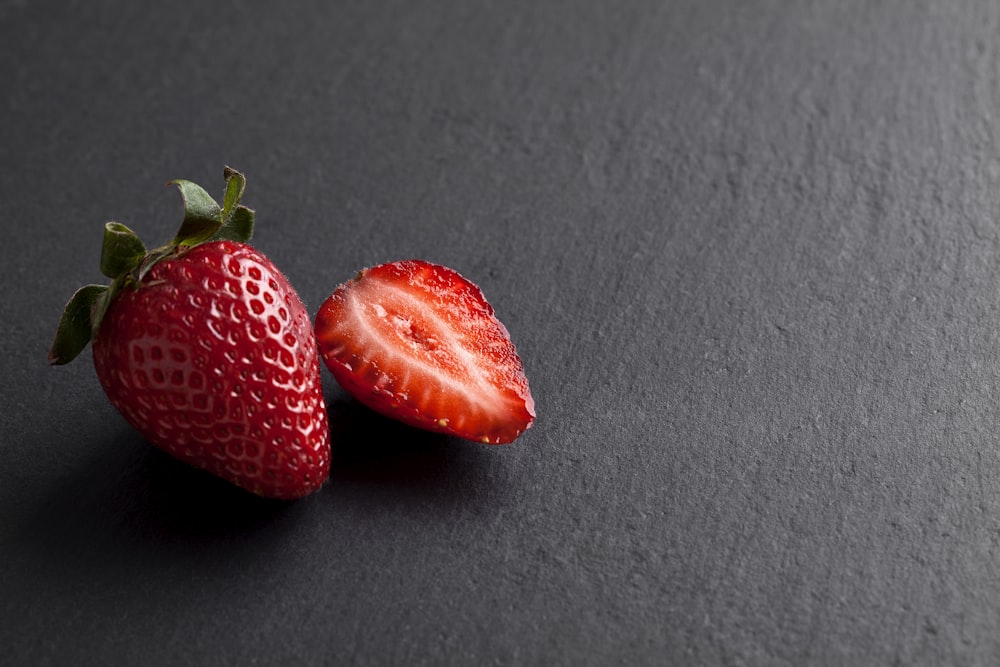 2 strawberries on gray textile