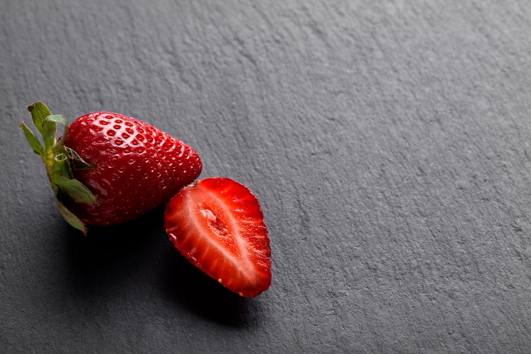 2 strawberries on white textile