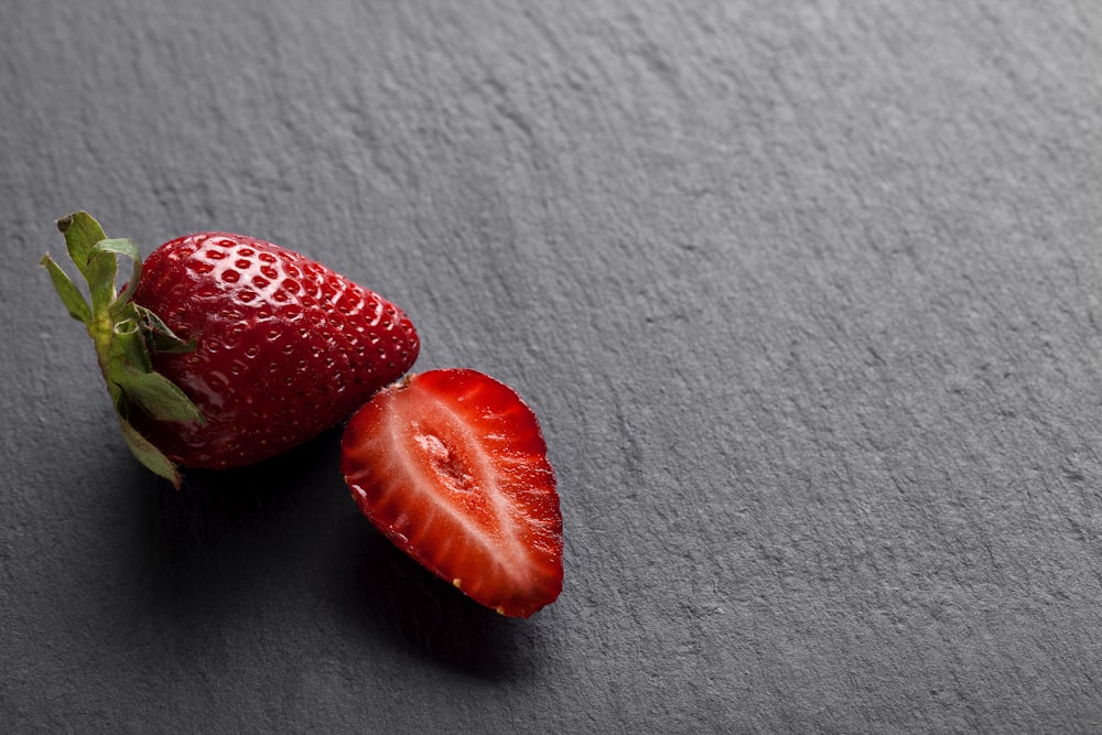 2 strawberries on white textile