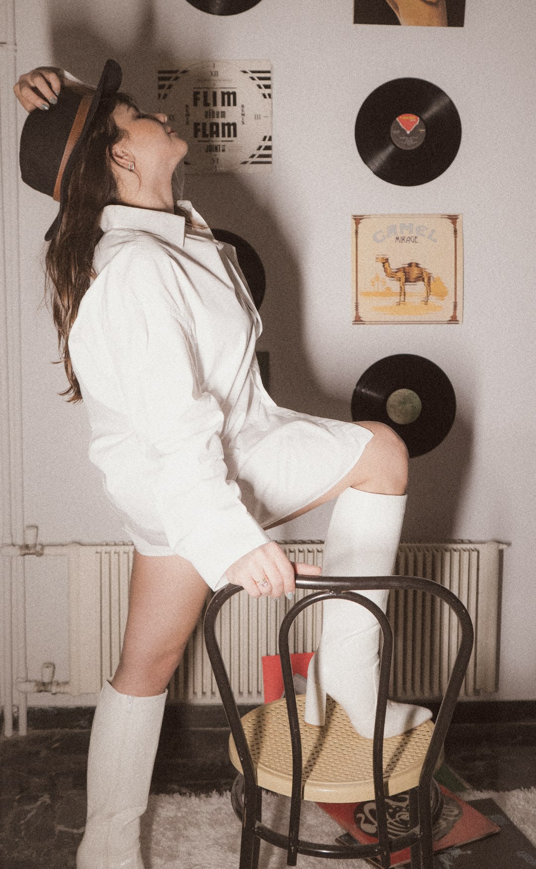 woman in white long sleeve shirt and black skirt standing on white chair