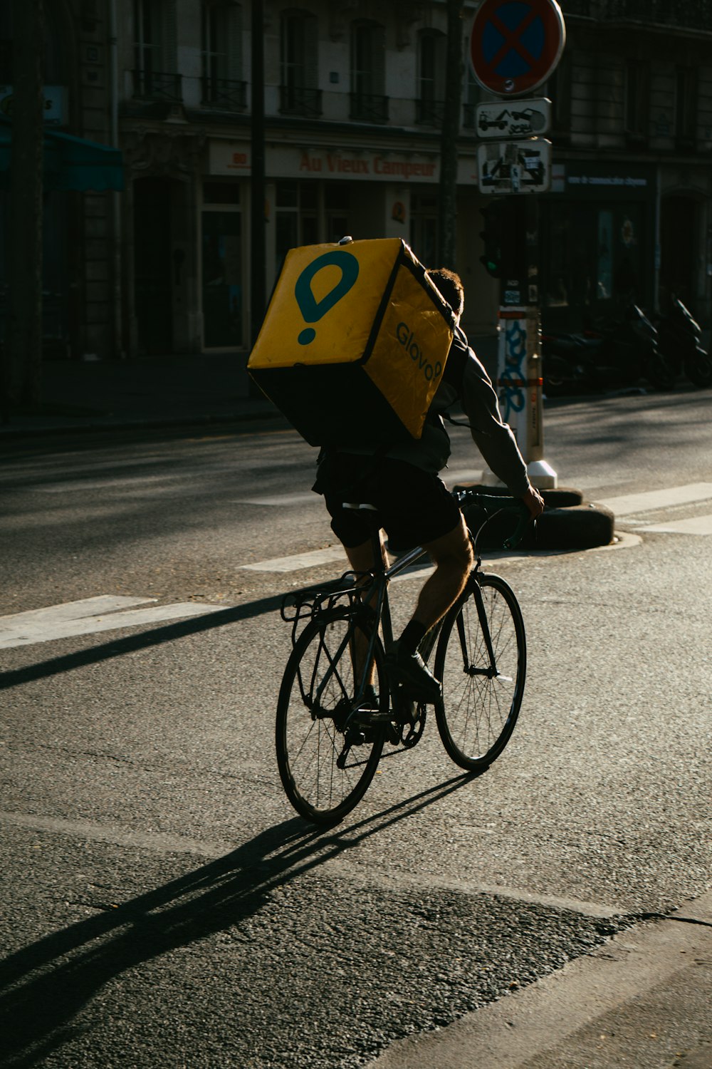 personne en veste noire roulant sur un vélo noir sur la route pendant la journée