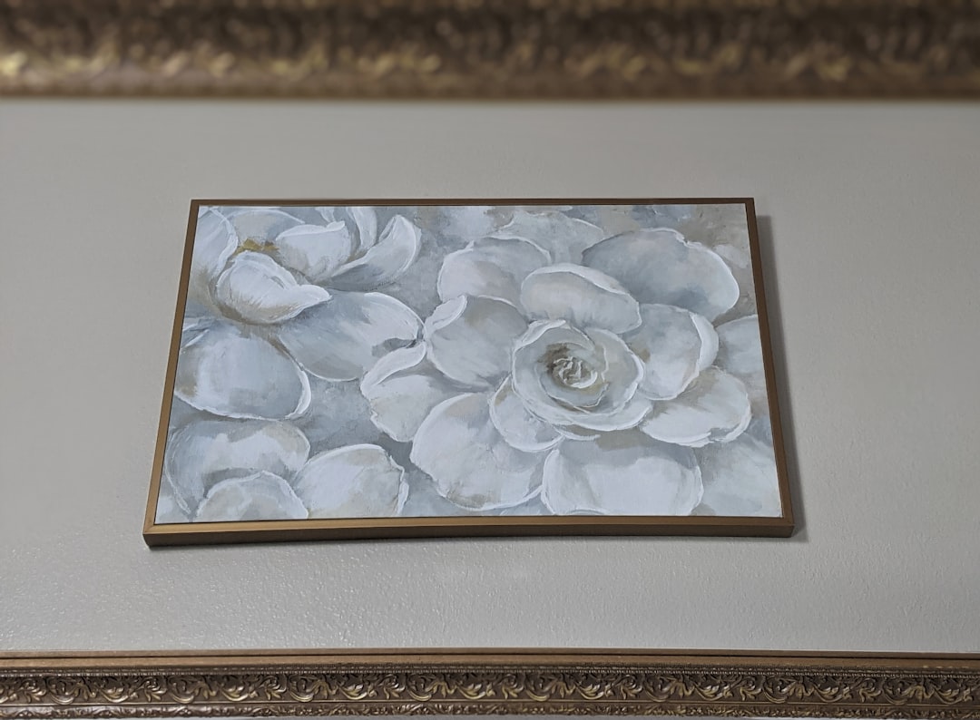 white flower painting on brown wooden frame