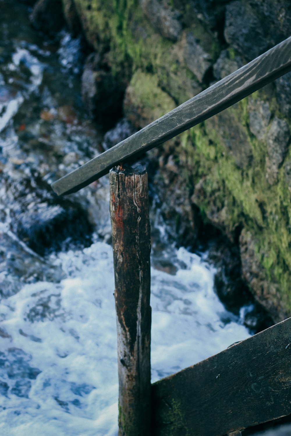 brown wooden post near water falls during daytime