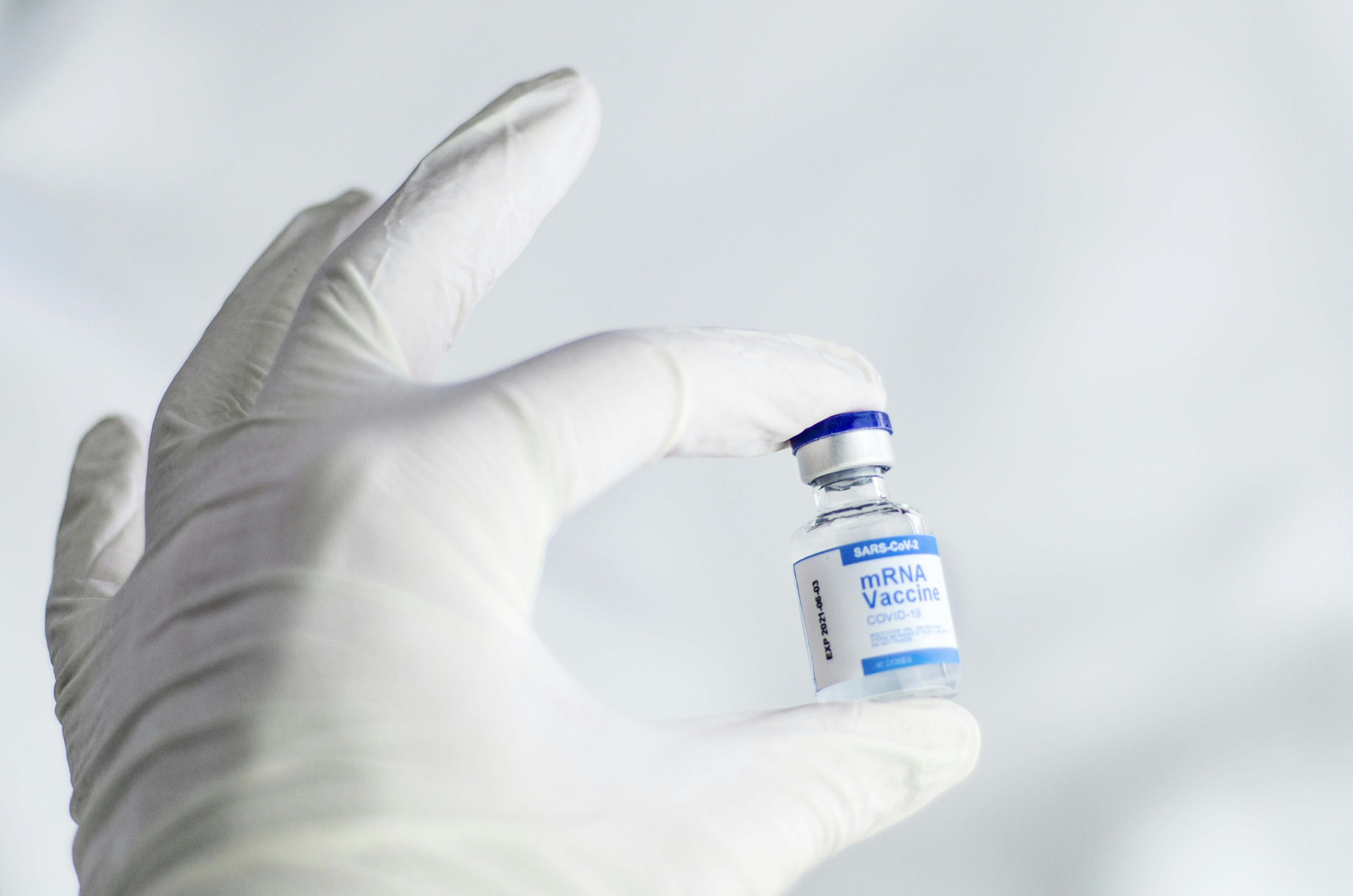 medical professional holding glass vaccine vial cold storage