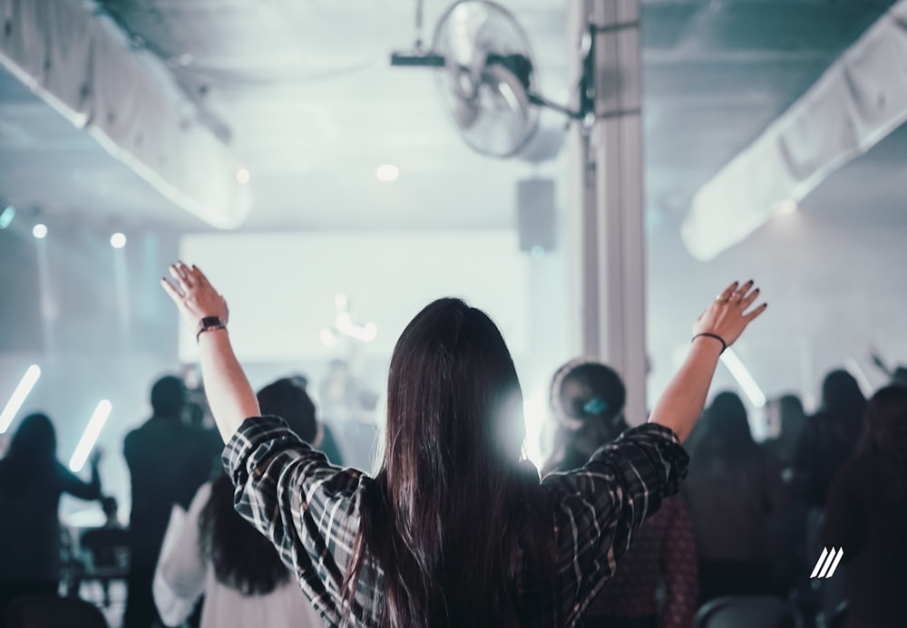 woman in black and white long sleeve shirt raising her hands