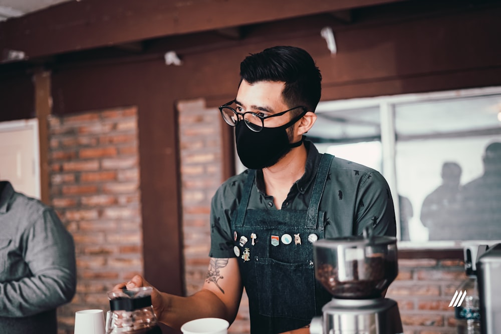 man in blue button up shirt holding cup