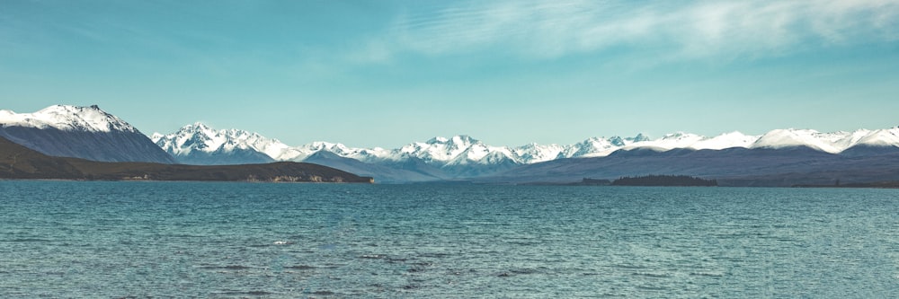 snow covered mountain near body of water during daytime