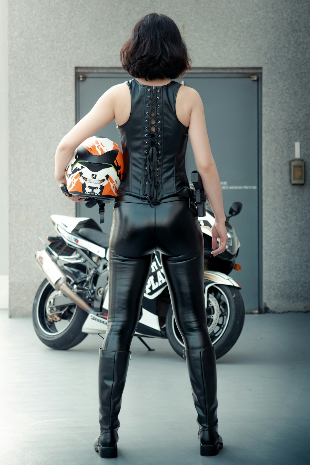 woman in black tank top and black leggings riding on black and silver motorcycle