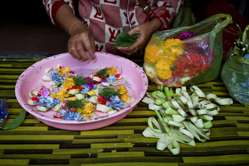 Woven palm-leaf offering with flowers on the ground
