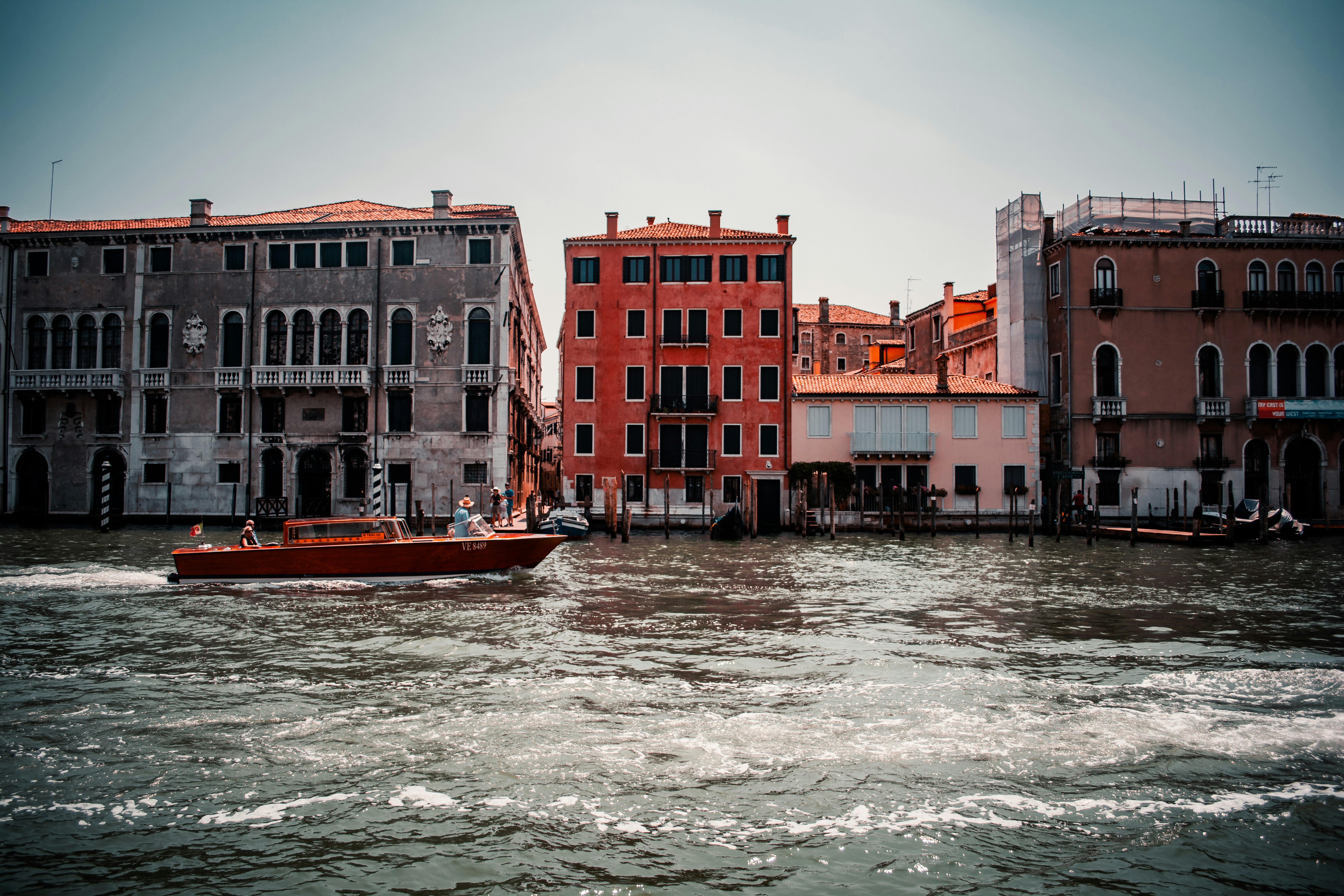 red and brown concrete building beside body of water during daytime, 