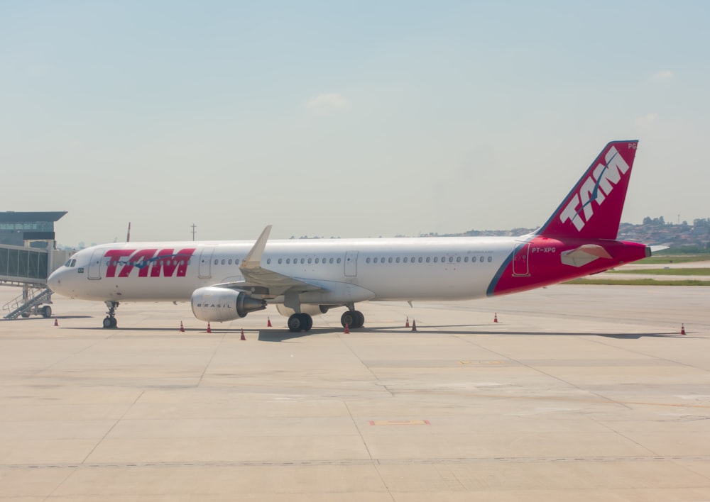 white and red air plane in the sky during daytime