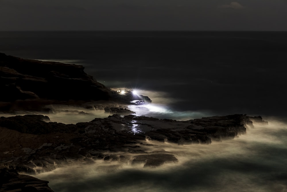 ocean waves crashing on shore during night time