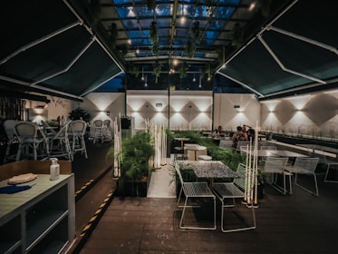 Guests enjoying a relaxing meal surrounded by green plants and soft warm lighting.