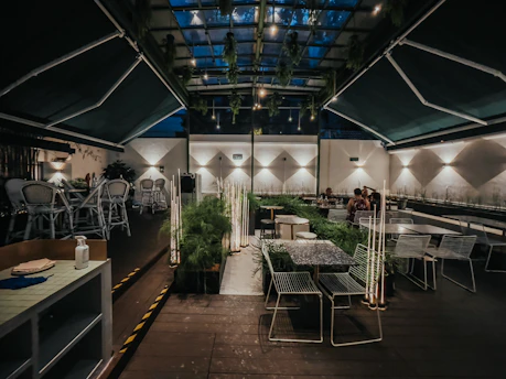 A cozy, elegant dining area at Brisa Plata with warm lighting and guests enjoying their meals.