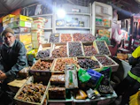 Hands carefully selecting fresh dates at a local market stall.