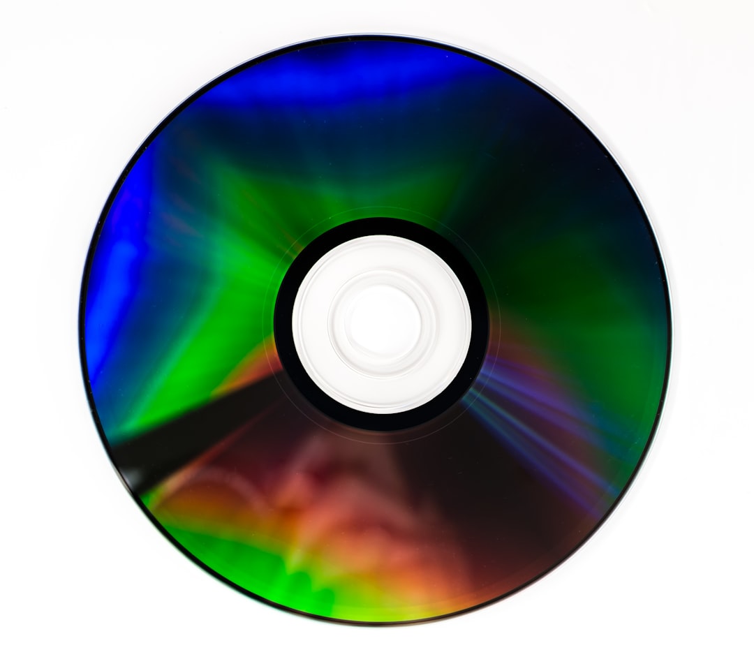 green blue and black compact disc, CD DVD compact optical disk storage medium with dust and scratches. Rainbow spectrum of iridescent colors
