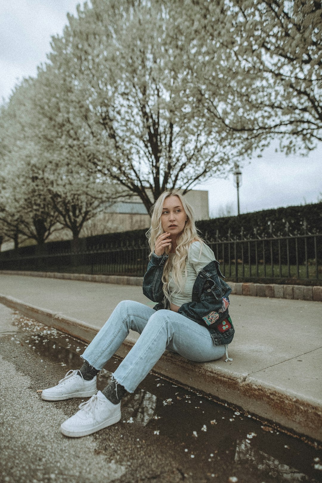 woman in blue denim jeans sitting on concrete bench
