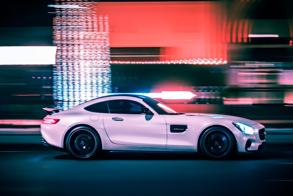 white porsche 911 parked in front of building