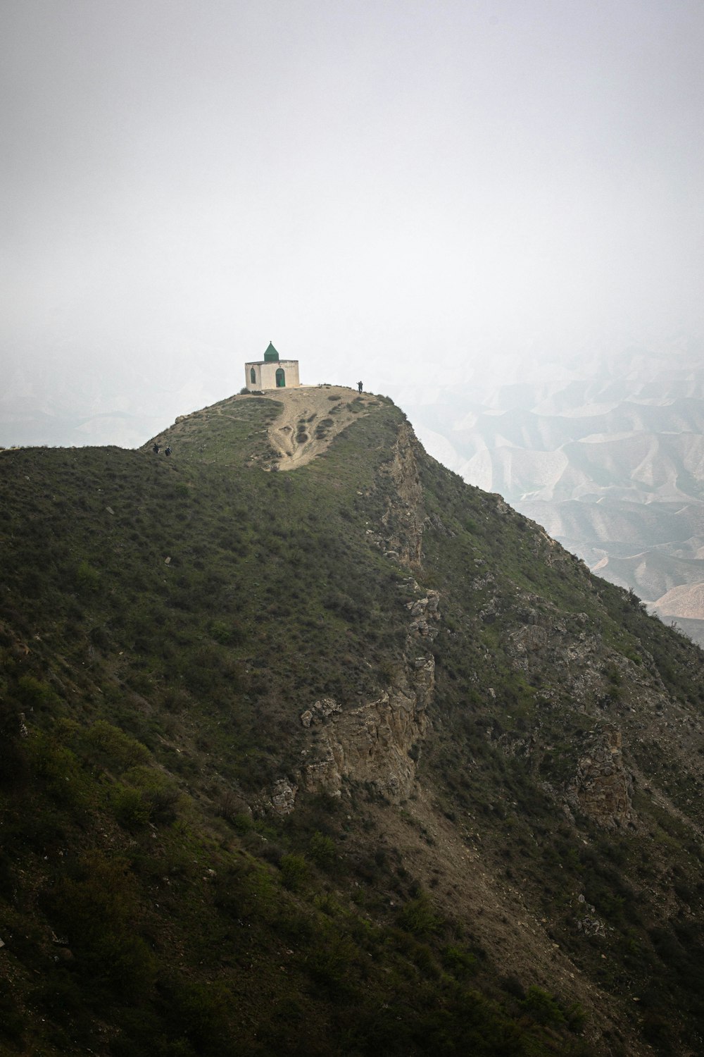 Château blanc et vert au sommet de la montagne