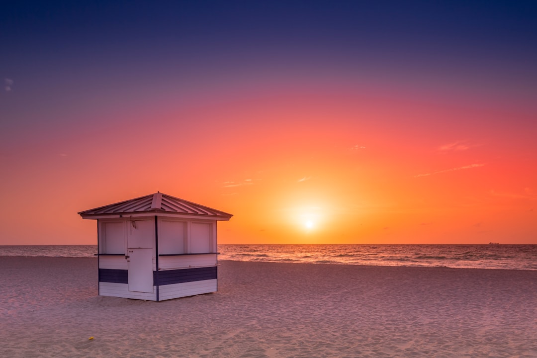 white wooden house on beach during sunset