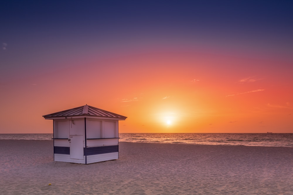 Weißes Holzhaus am Strand bei Sonnenuntergang