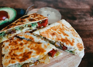 sliced pizza on brown wooden table