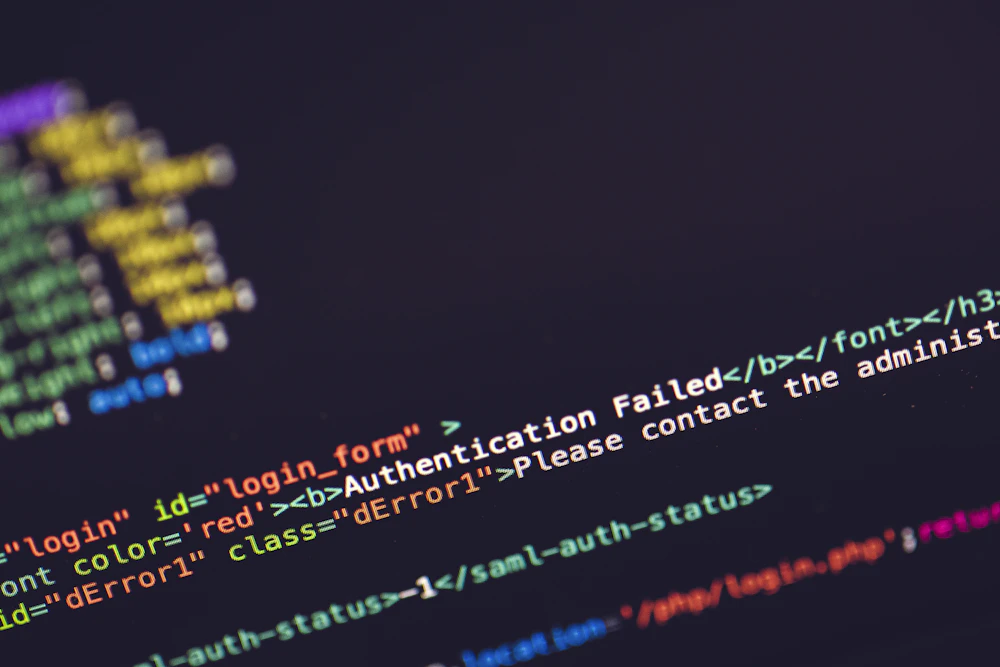 Close-up of a computer screen displaying HTML code with an error message stating "Authentication Failed. Please contact the administrator."