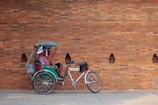 2 men riding on red and black trike