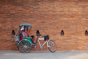 2 men riding on red and black trike