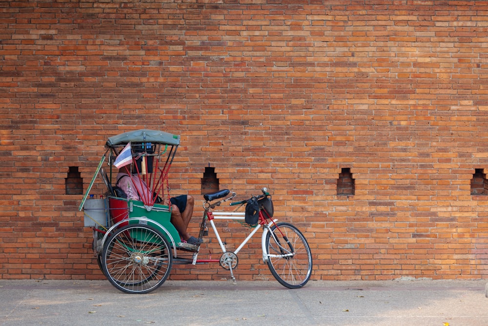 2 men riding on red and black trike